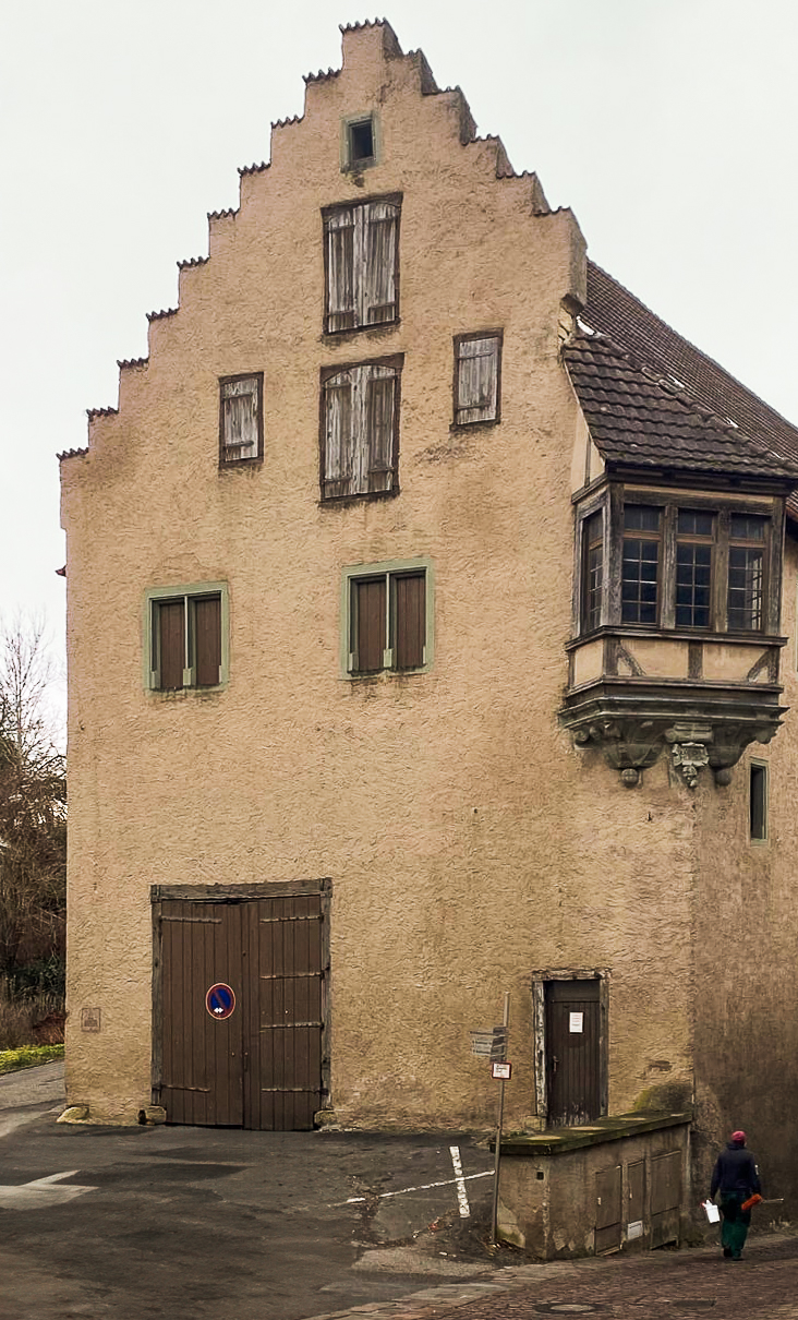 Ein altes Haus, welches scheunenähnlich ist undein treppenartiges Dach hat.